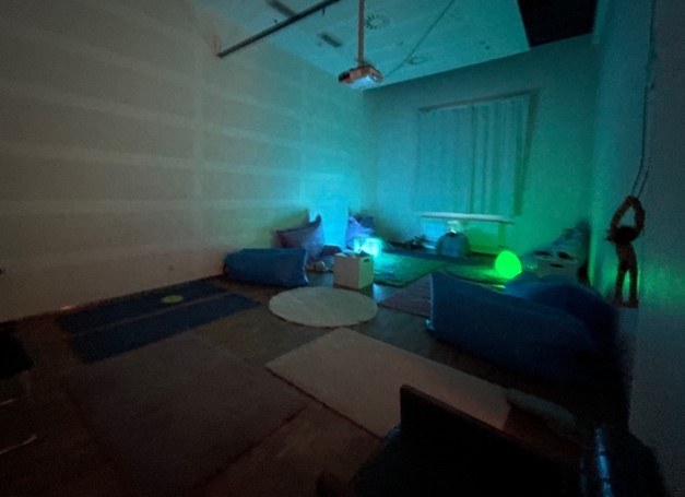 Image 4: Sensory room, with low blue-green lighting, soft furnishings and soft toys