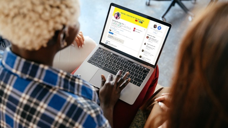 A black woman holds an open laptop on her lap. On the laptop is Dr. Gertrude Nonterah's LinkedIn profile.