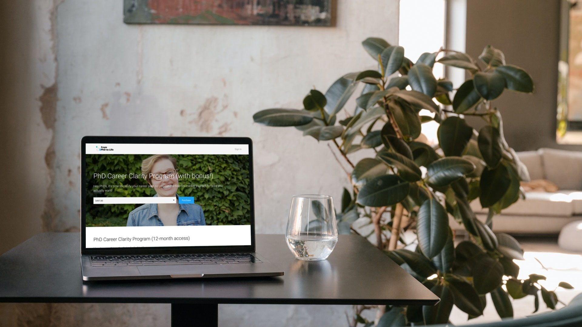 Jen Polk's PhD Career Clarity Program sign up page on a laptop screen. The laptop is on a small black table next to a stemless wineglass filled with water. In the background is a potted plant and in a couch.