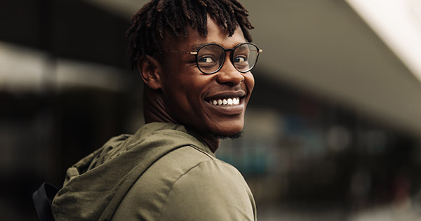 Student satisfaction at HBCUs: Male student walking past a university building. 
