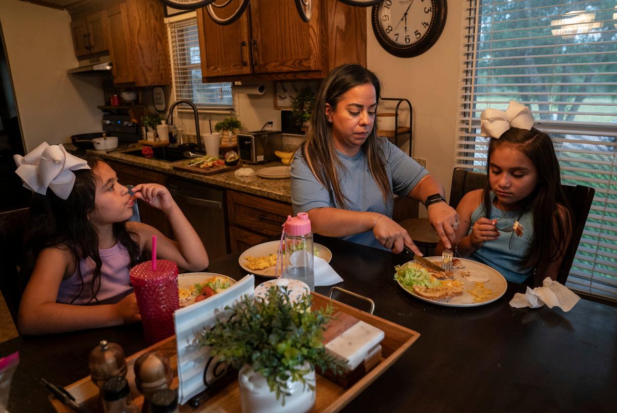 Clarissa Méndez, 44, and her daughters Catiana Ester Méndez, 7, left, and Catalaya Avaneh Méndez, 8, have diner at their home in Hebbronville, Texas on July 30, 2025. Méndez makes a daily one-hour commute to Laredo to work as a nurse. Currently she has her father or another person pick up her daughters from the daycare and take care of them for about an hour until she comes back from work. After picking up her daughters she cooks for them and spends some time with them before she starts working from home for an additional three to four hours. The family does not receive any government assistance and she does not have the support to take care of her daughters while she works. After school programs like ACE allow her to save some money in daycare costs in addition to her daughters learning entrepreneurial skills, get help with homework, etc.
Gabriel V. Cárdenas for The Texas Tribune