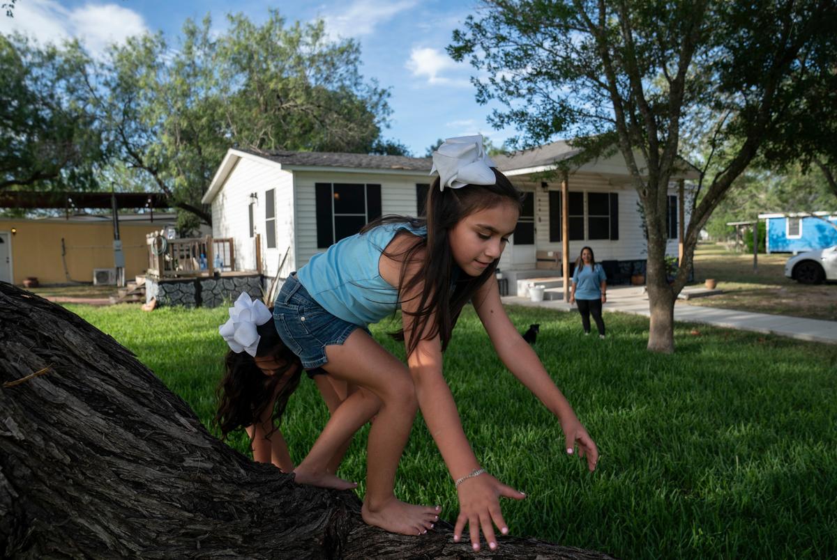 Catalaya Avaneh Méndez, 8, in front, plays with her sister Catiana Ester Méndez, 7, as their mother watches them
at her home in Hebbronville, Texas on July 30, 2025. They attend an after school program that allows for their mother to save money on childcare while she works. The Trump administration recently froze the funds for these programs to shortly unfroze them. There is uncertainty whether they will continue to have consistent funding for the programs. Termination of the programs would put financial stress on parents such as the Méndez who receive no government assistance as they will have to pay for daycare for their children.
Gabriel V. Cárdenas for The Texas Tribune