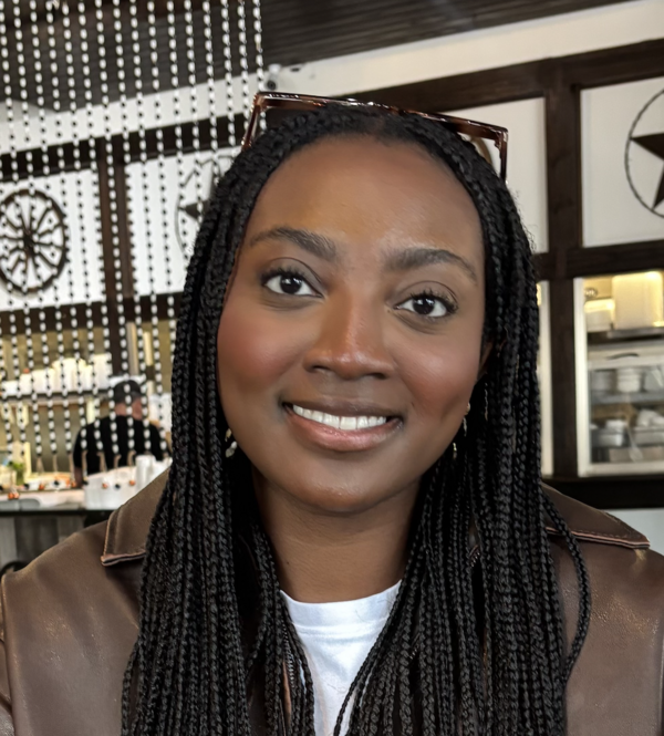 Daisy Partey, a young Black woman with long, thin braids and sunglasses propped on her head.
