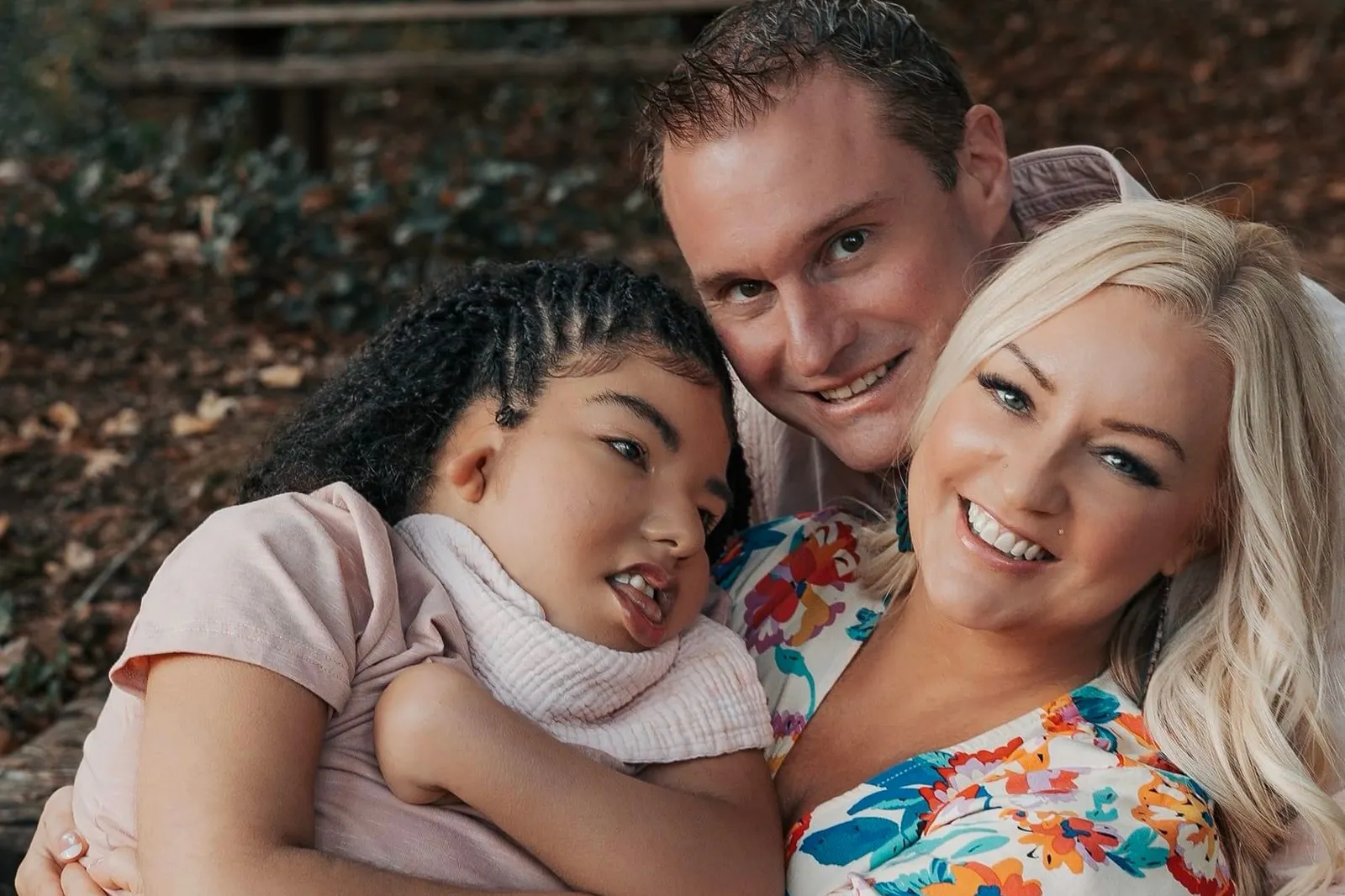 The people are in an embrace and pictured outside.