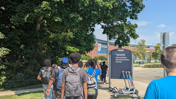 Founder’s students in backpacks walking toward buillding
