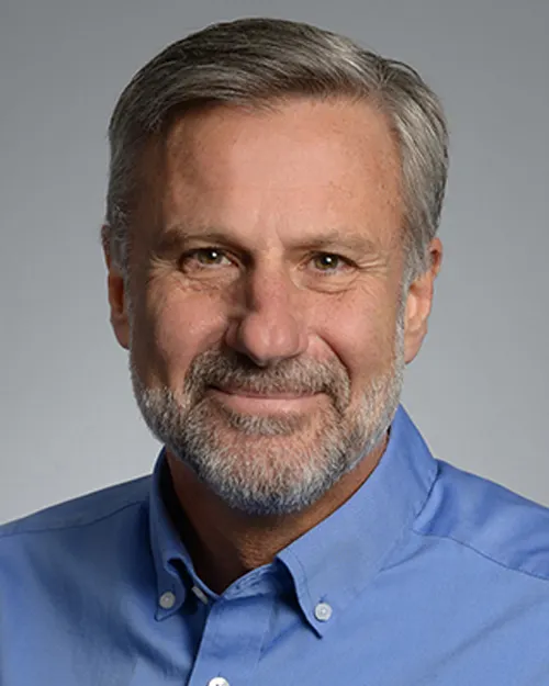 A person is looking at the camera. Their head and shoulders are seen.