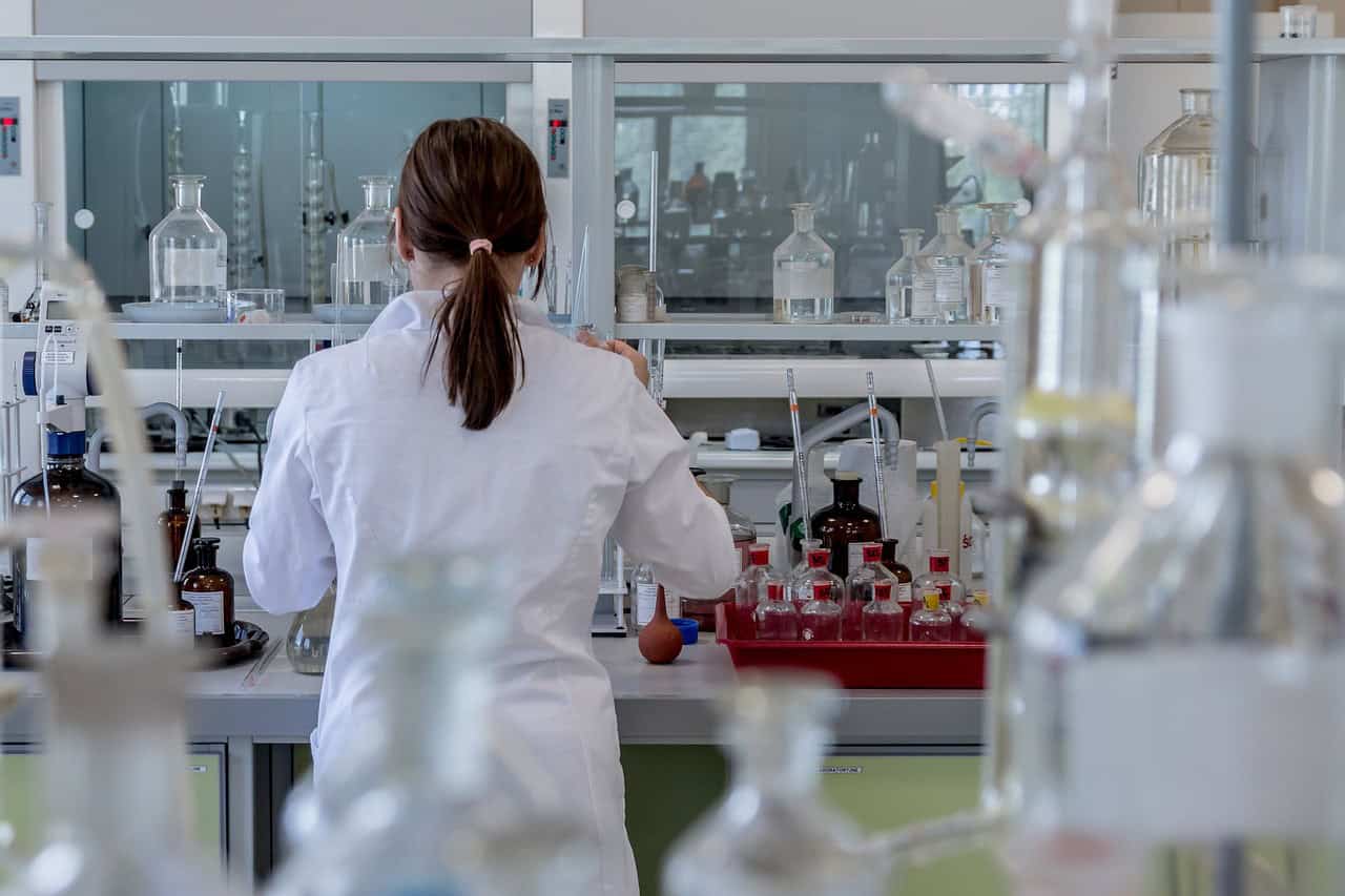 Woman facing away from camera working in science research lab.